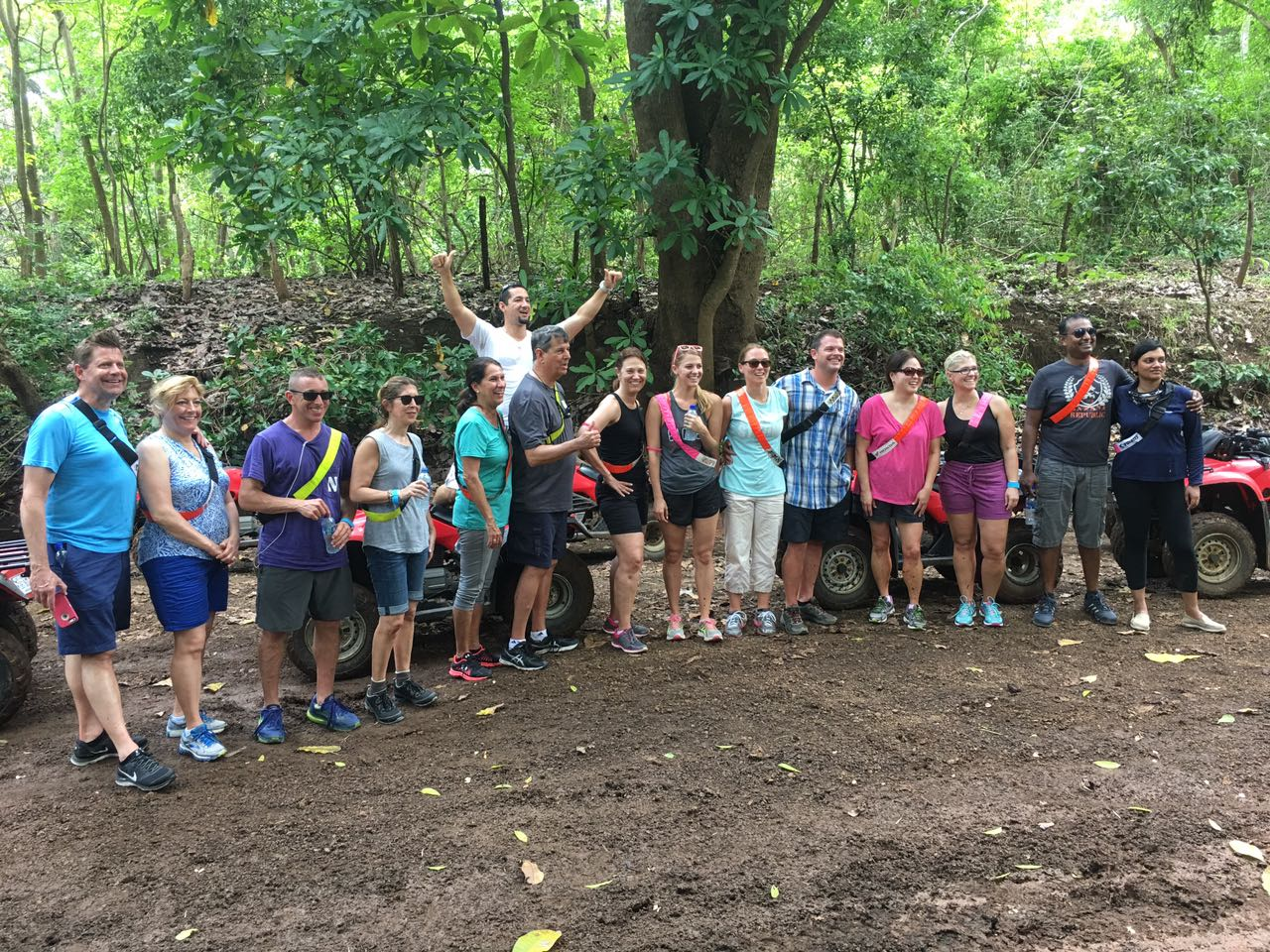 Large group of travelers posing before a guided ATV tour in the Guanacaste dry forest of Costa Rica