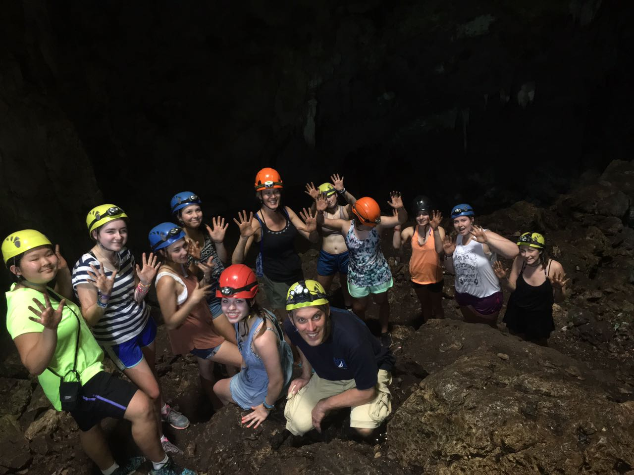 Group of travelers with headlamps exploring the interior of Venado Caves in Costa Rica